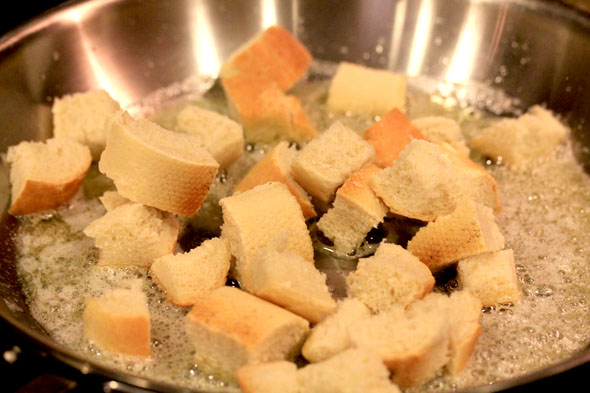 add the bread. quickly toss around so that it soaks up the oil/butter mixture evenly.