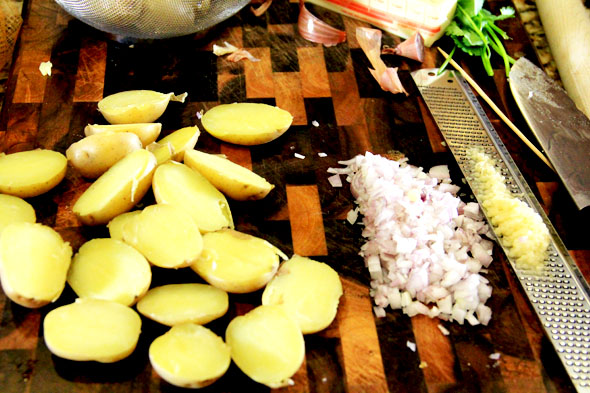 Once the potatoes are cool enough to handle, gently slice them in half lengthwise.