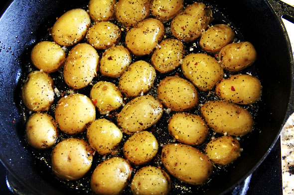 Season the potatoes with a generous pinch of coarse sea salt, crushed red pepper flake, and black pepper. Notice how the oil is nearly soaked up? Awwww sookie sookie now!