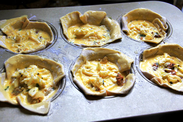 Pour the egg and cheese mixture evenly inside each tin, careful not to let too much of it leak down the sides of the pastry.