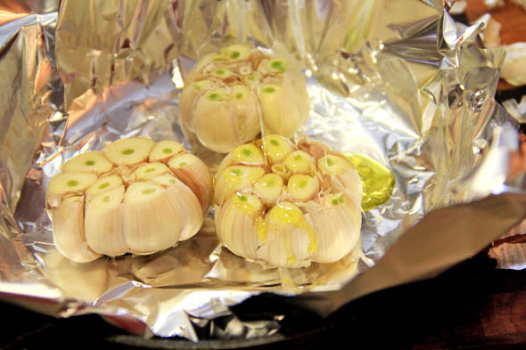 Place the garlic bulbs inside of a piece of foil large enough to fold over the garlic and close. Drizzle the tops with a little olive oil, making sure the oil gets in between each clove.