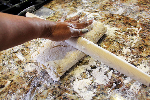 roll the dough out into another rectangle, pressing those layers together so that they're sealed.