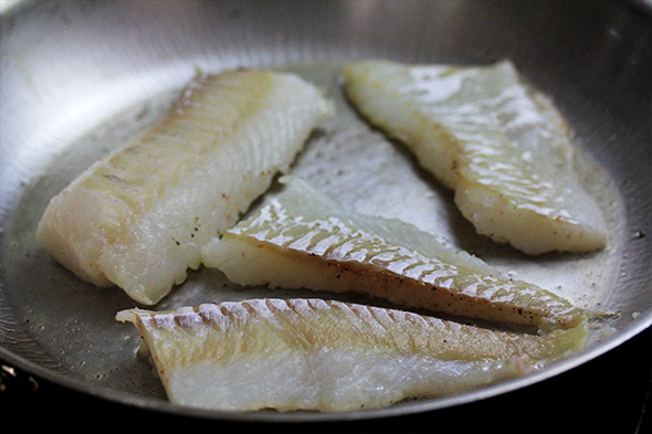 gently place each piece of fish down, making sure there's enough oil underneath every piece so it doesn't stick too badly.