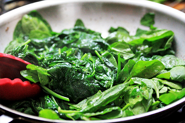 start to gently flip the spinach around and at this point, turn off the heat. the residual heat will continue to cook and wilt the spinach down. 