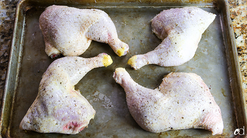 raw chicken leg quarters on sheet pan