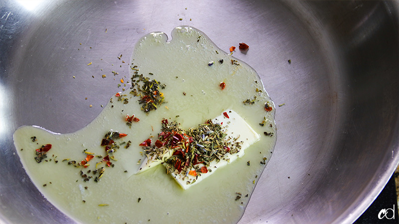 butter melting with crushed red pepper and herbs de provence