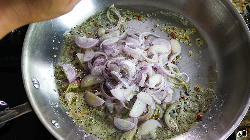 sprinkling kosher salt on shallots