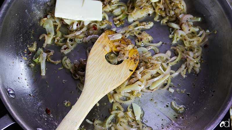 adding butter to shallots and garlic