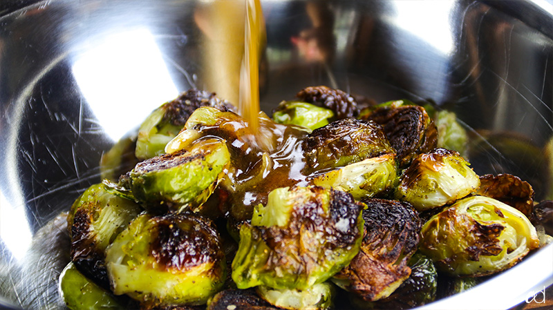 pouring miso honey brown butter over mussels