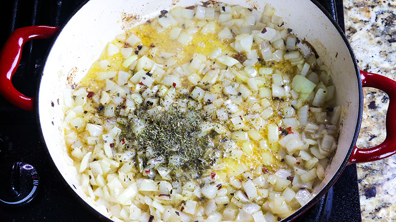 dried thyme and oregano added to onions