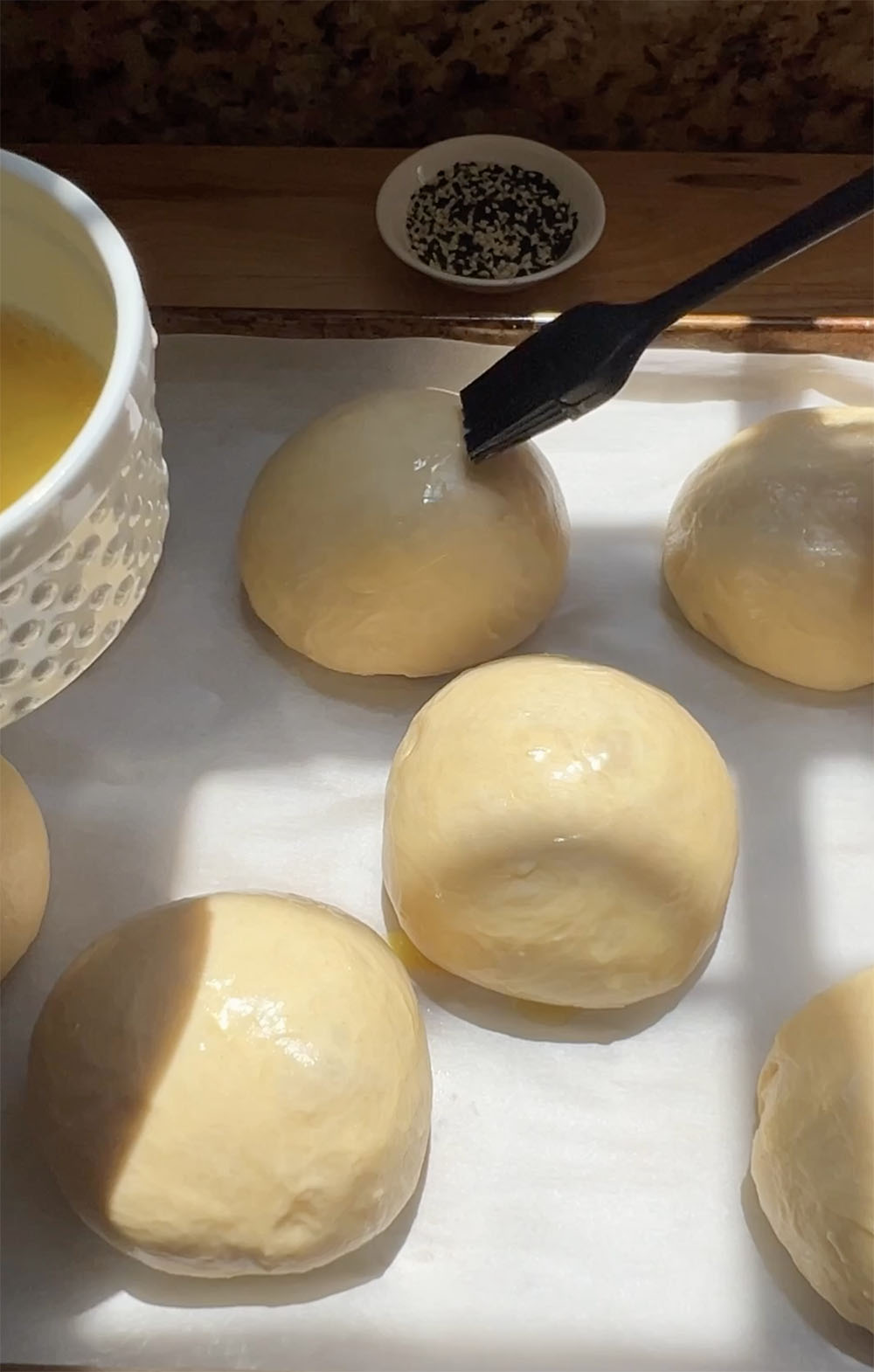 brushing buns with egg wash